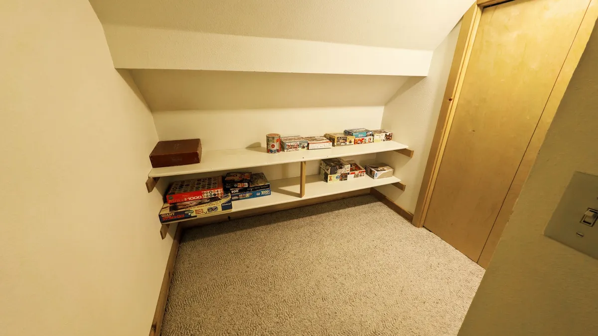 This image features shelves stocked with board games next to a wooden door, suggesting opportunities for fun, friendly competition, and bonding inside the condo between outdoor adventures.